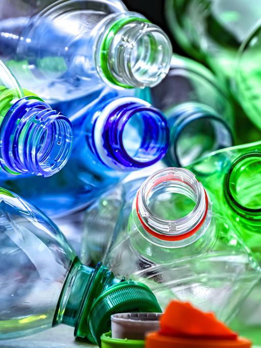 Bunte Plastikflaschen liegen mit der Öffnung zur Kamera durcheinander. Die Deckel sind alle abgeschraubt. Bunte Plastikflaschen liegen mit der Öffnung zur Kamera durcheinander. Die Deckel sind alle abgeschraubt.