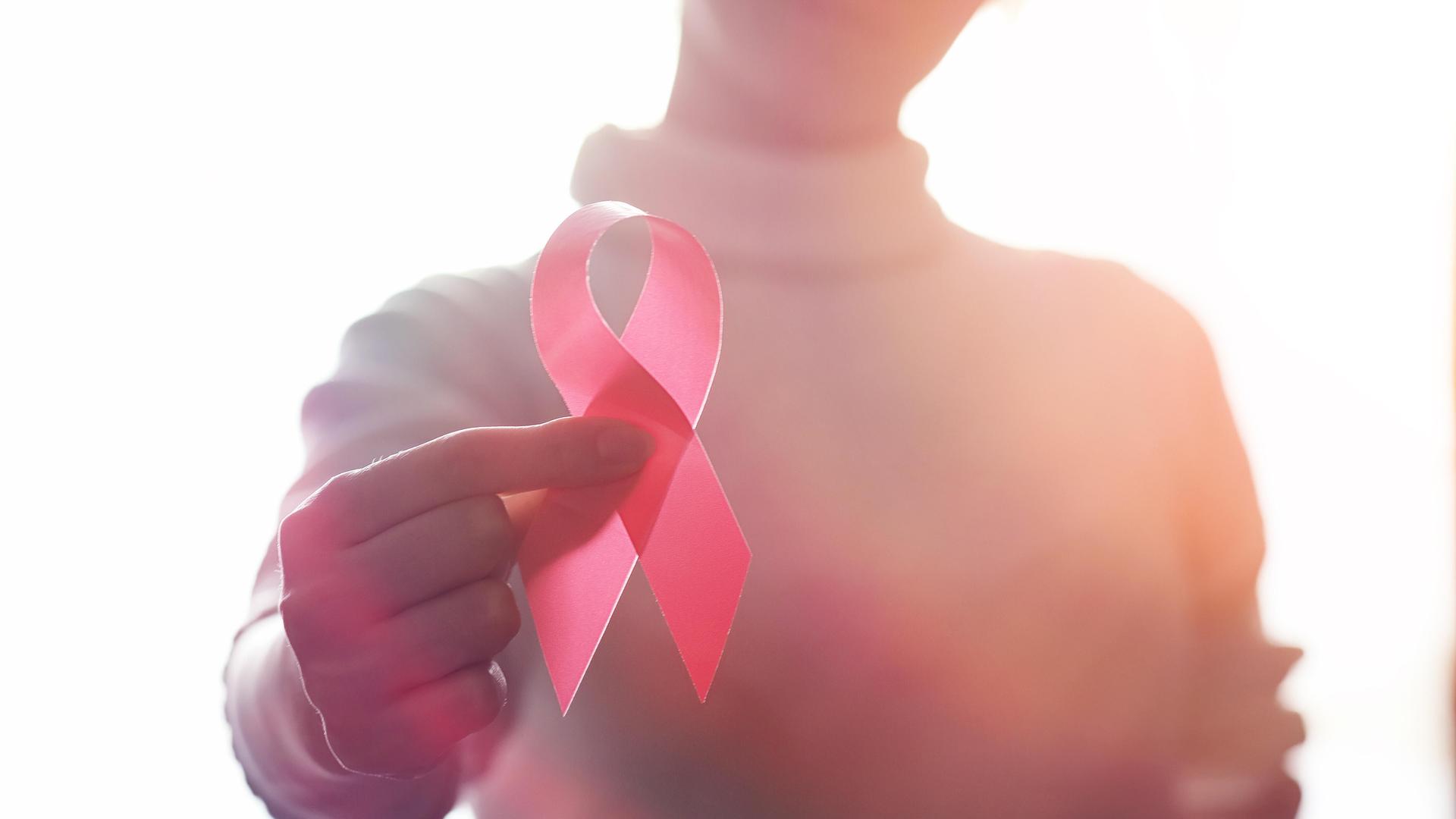 Ein Mensch hält eine große Schleife hoch, Symbol für Kampf gegen HIV Ein Mensch hält eine große Schleife hoch, Symbol für Kampf gegen HIV