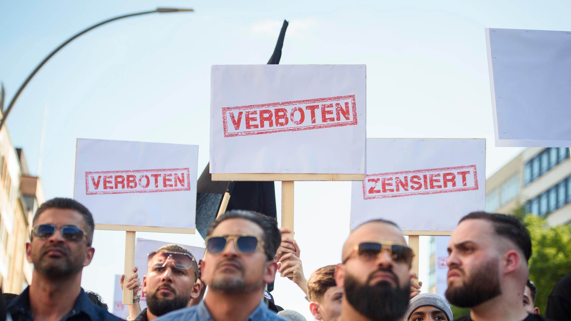 Demonstranten halten Schilder mit den Aufdrucken «Verboten» und «Zensiert» auf einer Kundgebung des islamistischen Netzwerks Muslim Interaktiv im Hamburger Stadtteil St. Georg in die Höhe (11.05.2023)