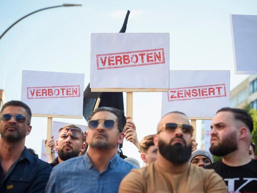 Demonstranten halten Schilder mit den Aufdrucken «Verboten» und «Zensiert» auf einer Kundgebung des islamistischen Netzwerks Muslim Interaktiv im Hamburger Stadtteil St. Georg in die Höhe (11.05.2023)