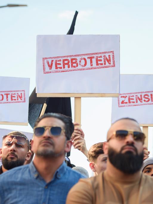 Demonstranten halten Schilder mit den Aufdrucken «Verboten» und «Zensiert» auf einer Kundgebung des islamistischen Netzwerks Muslim Interaktiv im Hamburger Stadtteil St. Georg in die Höhe (11.05.2023)