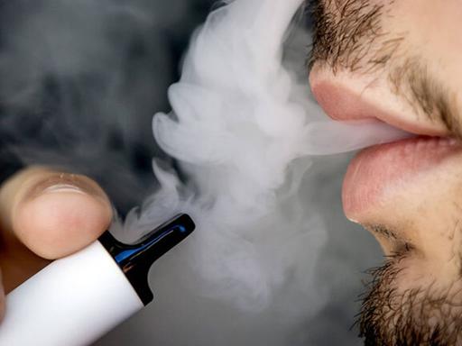 Ein Mann raucht eine Einweg-E-Zigarette