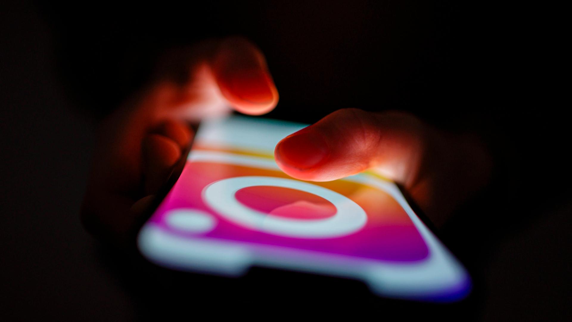 Kinderhände berühren das leuchtende Display eines Smartphones Kinderhände berühren das leuchtende Display eines Smartphones