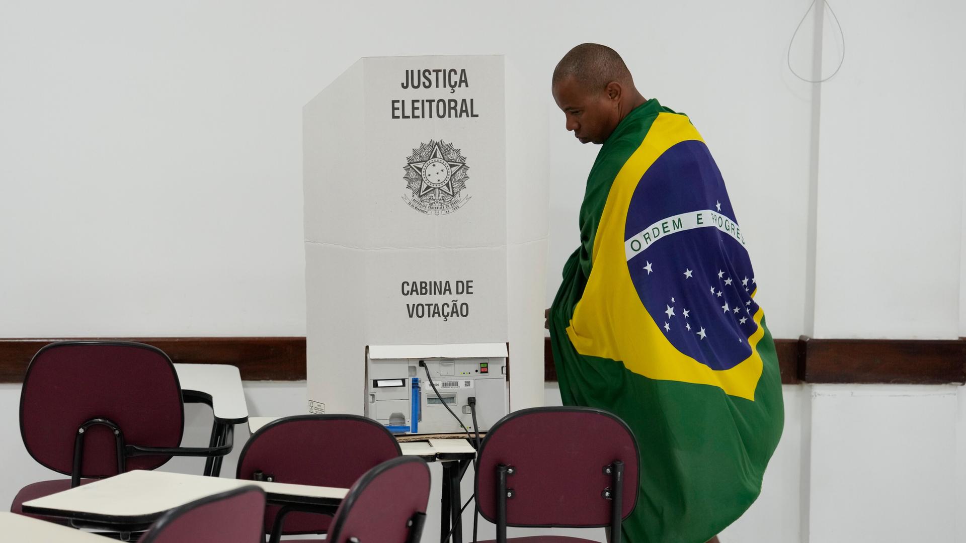 Ein Wähler, gehüllt in die brasilianische Flagge, bei den Präsidentschaftswahlen am 4.10.2026 in Brasilia, Brasilien Ein Wähler, gehüllt in die brasilianische Flagge, bei den Präsidentschaftswahlen am 4.10.2026 in Brasilia, Brasilien