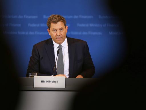 Finanzminister Lars Klingbeil bei der Bekanntgabe der Ergebnisse der Steuerschätzung für 2026 bis 2030. Er sitzt und spricht in ein Mikro vor sich. Er trägt Anzug und Schlips.