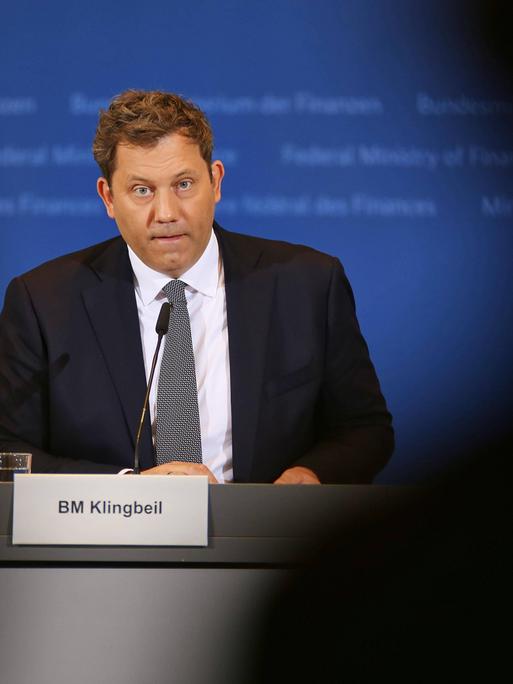 Finanzminister Lars Klingbeil bei der Bekanntgabe der Ergebnisse der Steuerschätzung für 2026 bis 2030. Er sitzt und spricht in ein Mikro vor sich. Er trägt Anzug und Schlips.