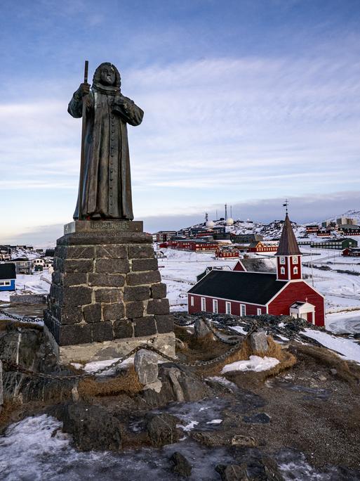 In der grönländischen Stadt Nuuk steht eine Statue des Missionars Hans Egede. Im Hintergrund ist die Stadt zu sehen.
