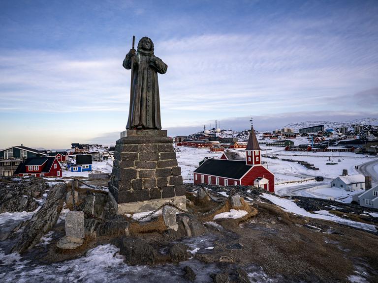 In der grönländischen Stadt Nuuk steht eine Statue des Missionars Hans Egede. Im Hintergrund ist die Stadt zu sehen.