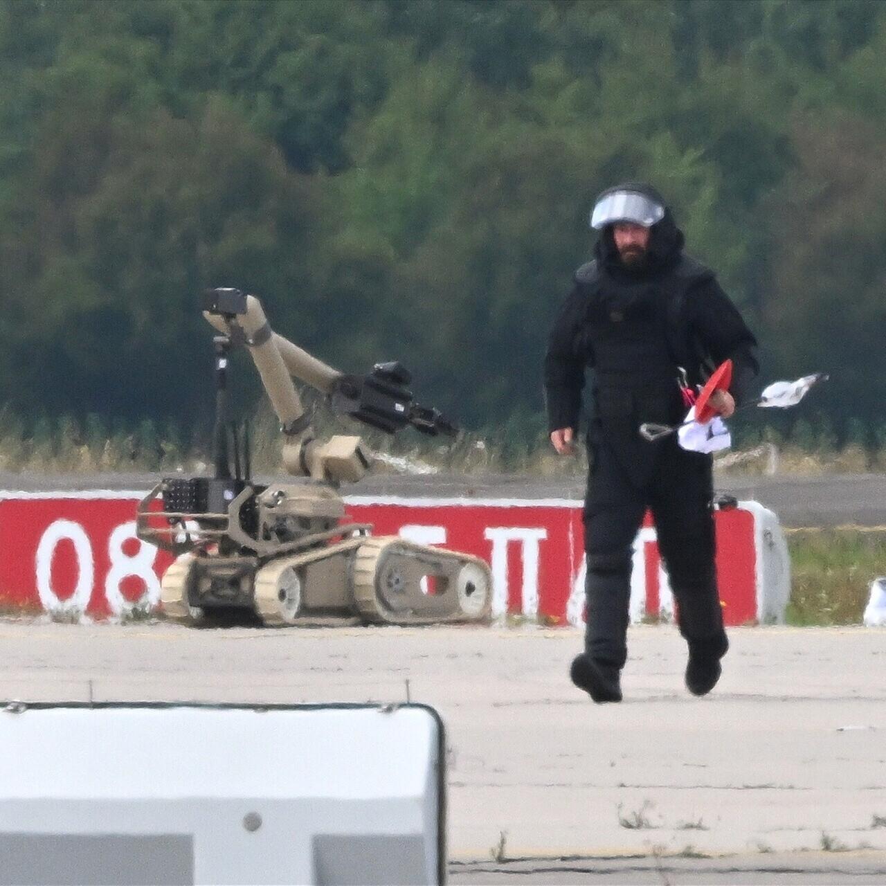 Ein Kriminaltechniker geht auf dem Flughafen Leipzig/Halle neben einem Sprengroboter, um die Drohne zu entschärfen.