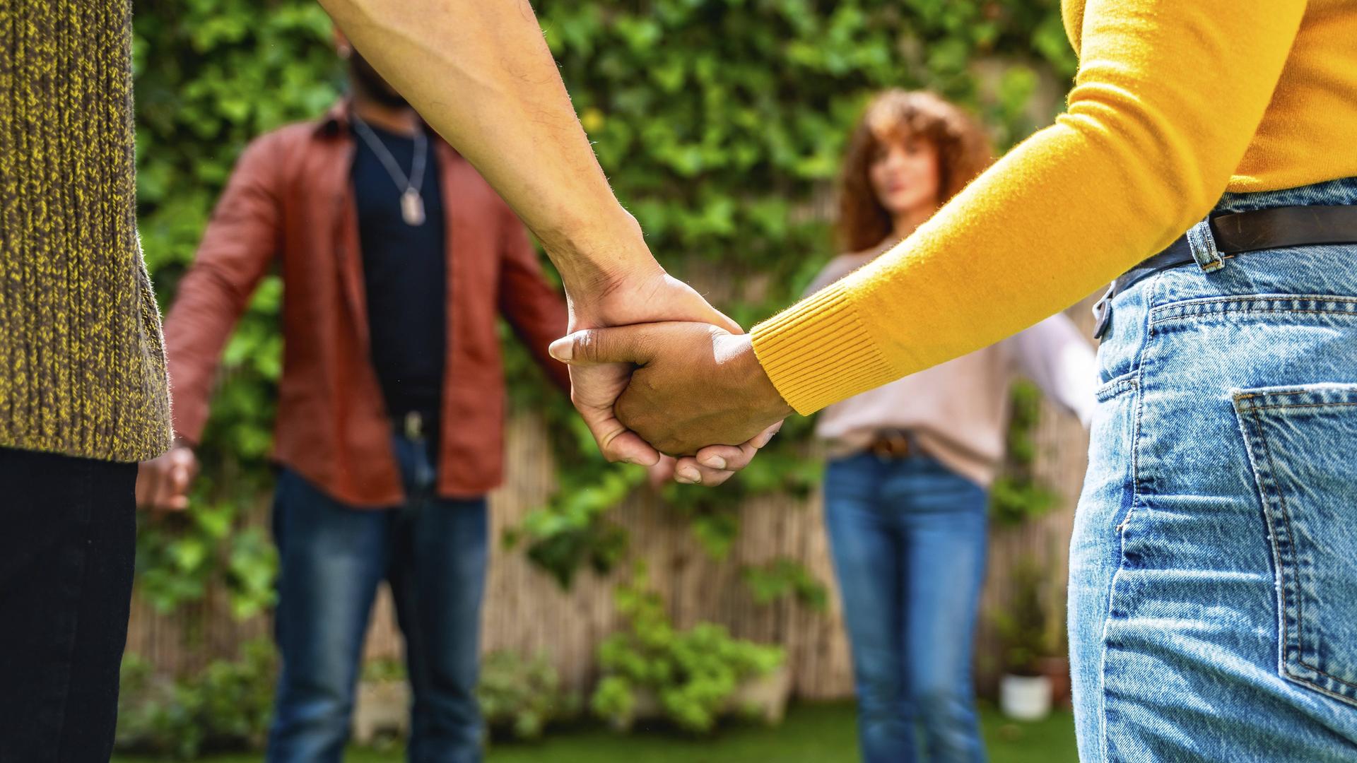 Verschiedene Menschen bilden einen Kreis und halten sich an den Händen Verschiedene Menschen bilden einen Kreis und halten sich an den Händen