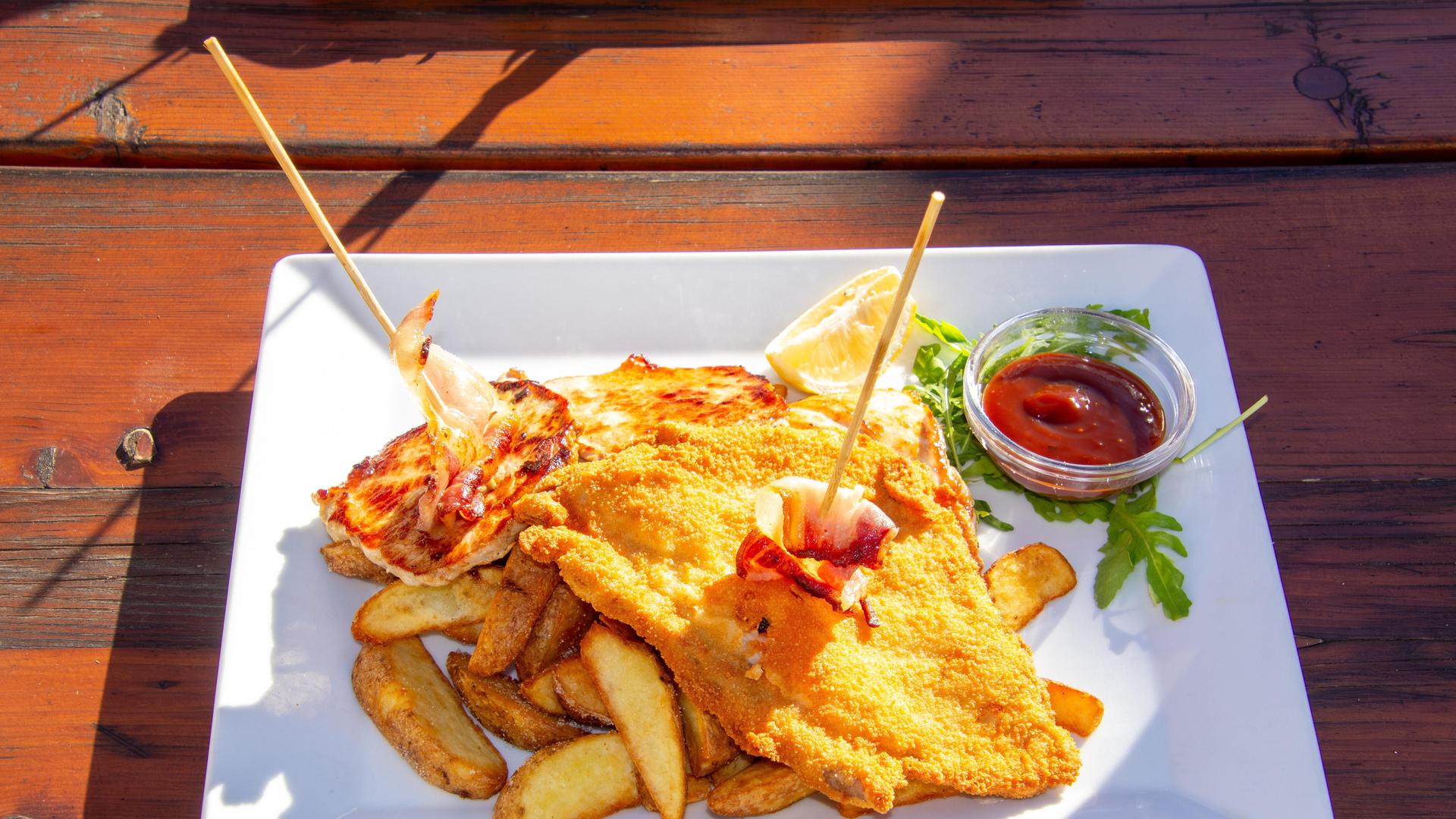 Teller mit Schnitzel, Pommes und Ketchup Teller mit Schnitzel, Pommes und Ketchup