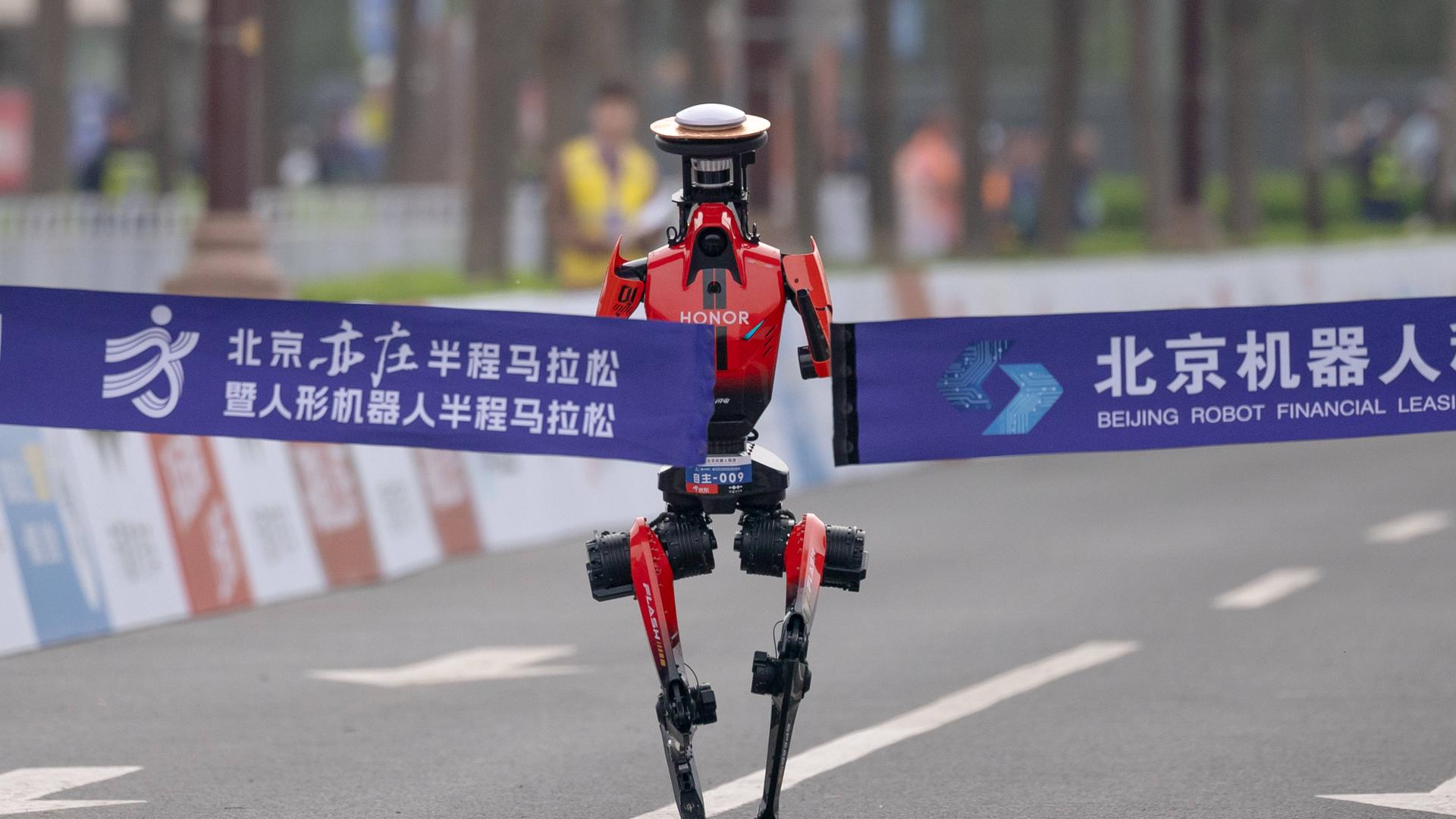 Ein Roboter der chinesischen Smartphone-Marke Honor läuft bei einem Halbmarathon in Peking ins Ziel und gewinnt