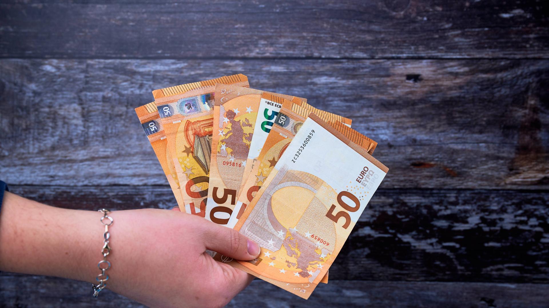 Eine Hand hält 50-Euro-Scheine Eine Hand hält 50-Euro-Scheine