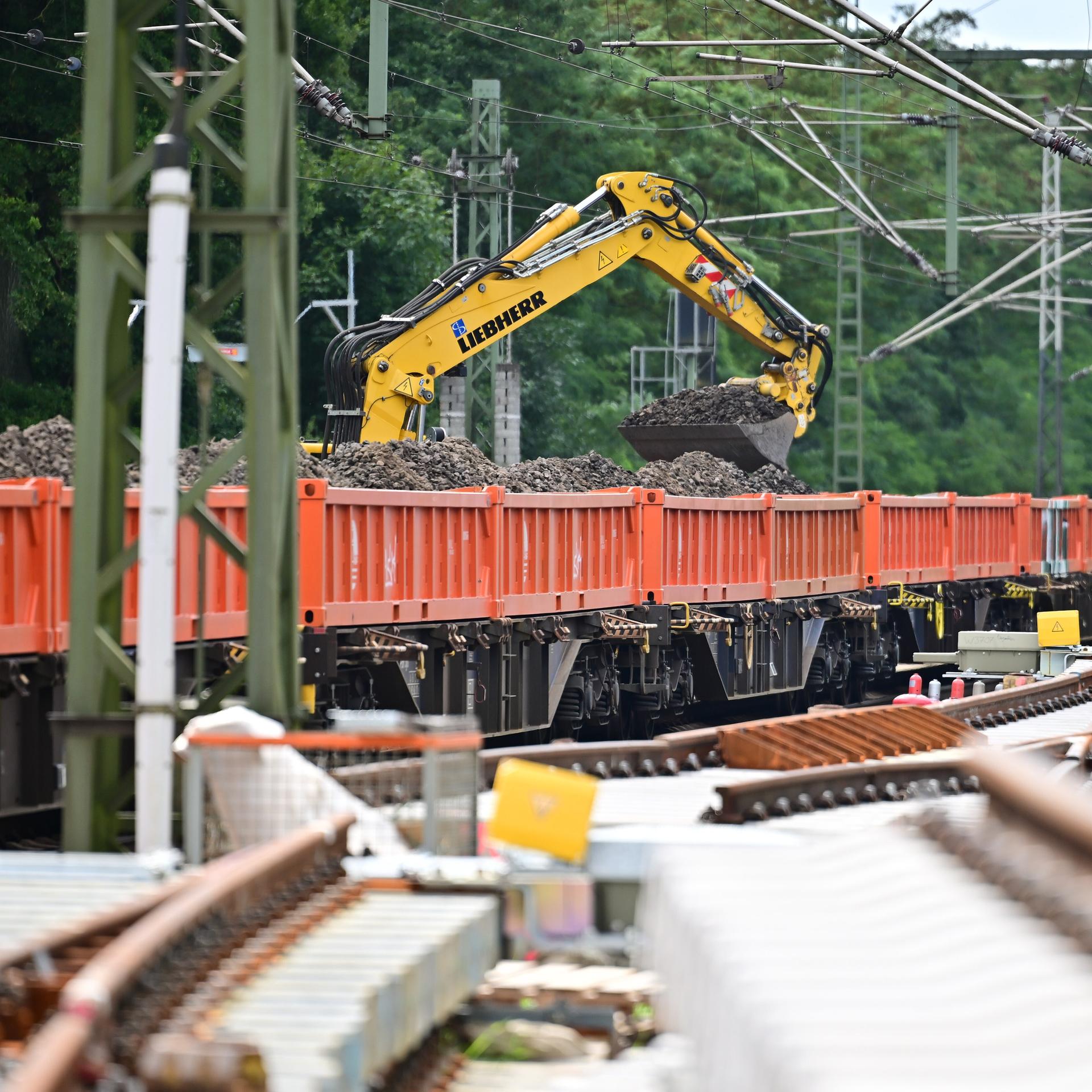 Ein Bagger hebt Schotter von einem Waggon. Das Bild zeigt die Generalsanierung der Strecke Hamburg / Berlin.