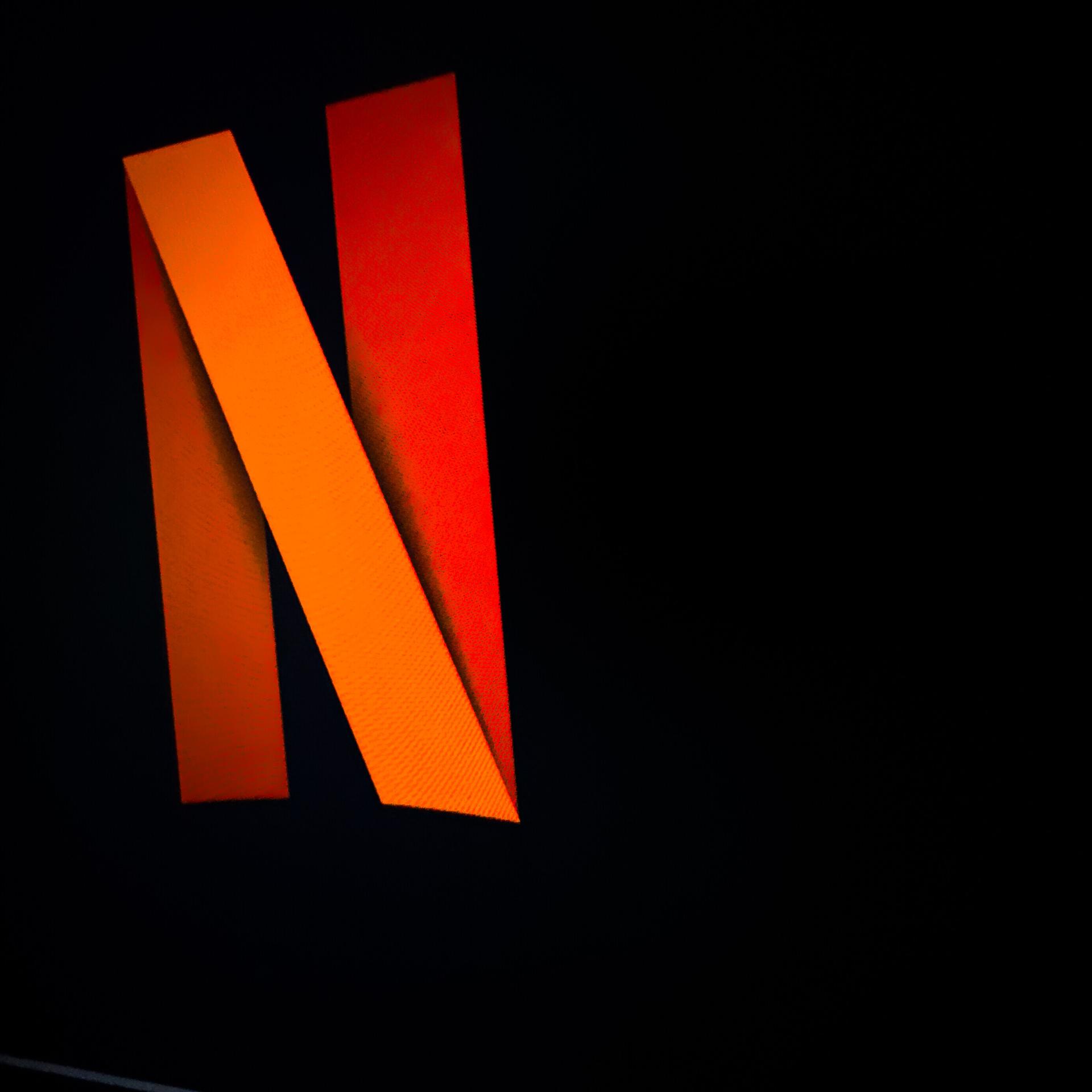 Der Buchstabe N, rotgefärbt vor schwarzem Hintergrund, aus dem Schriftzug des Streaminganbieters Netflix.