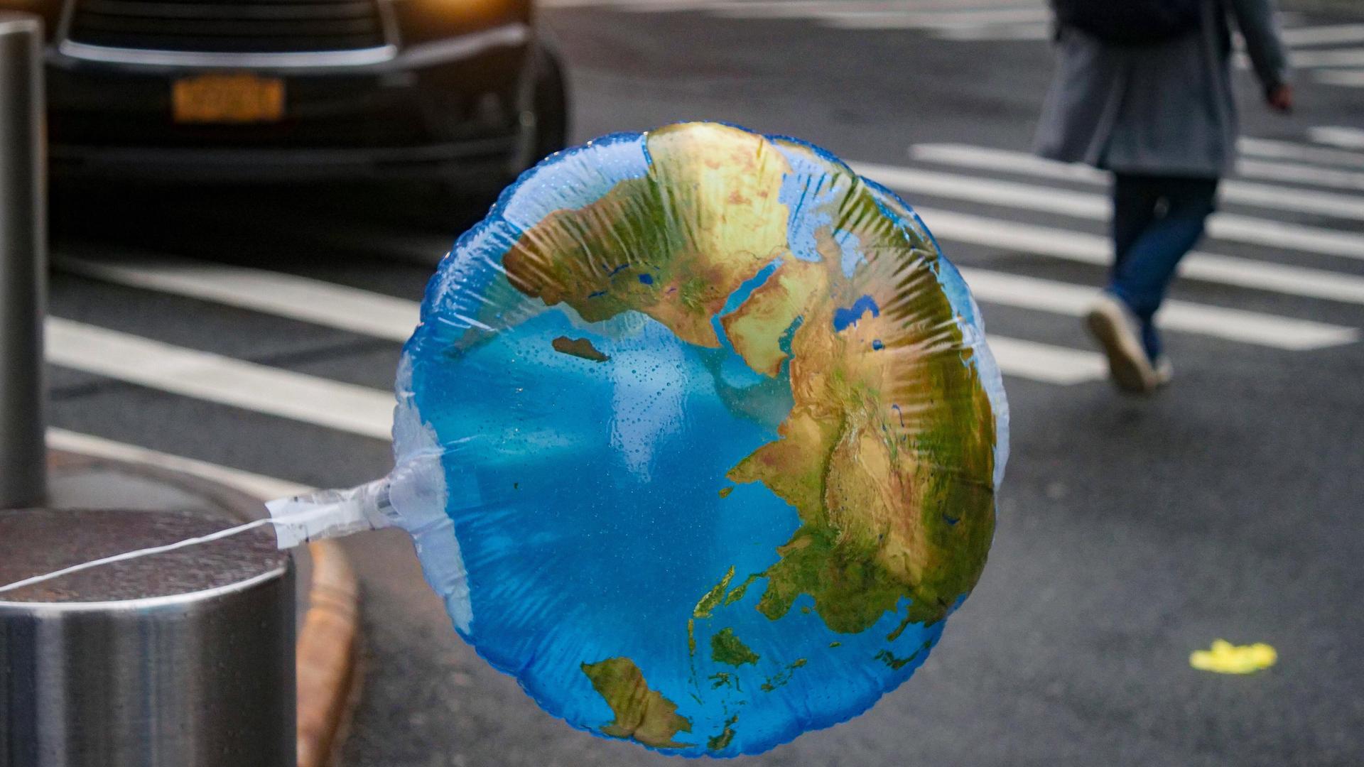 Ein Luftballon mit einer Weltkarte weht im Wind