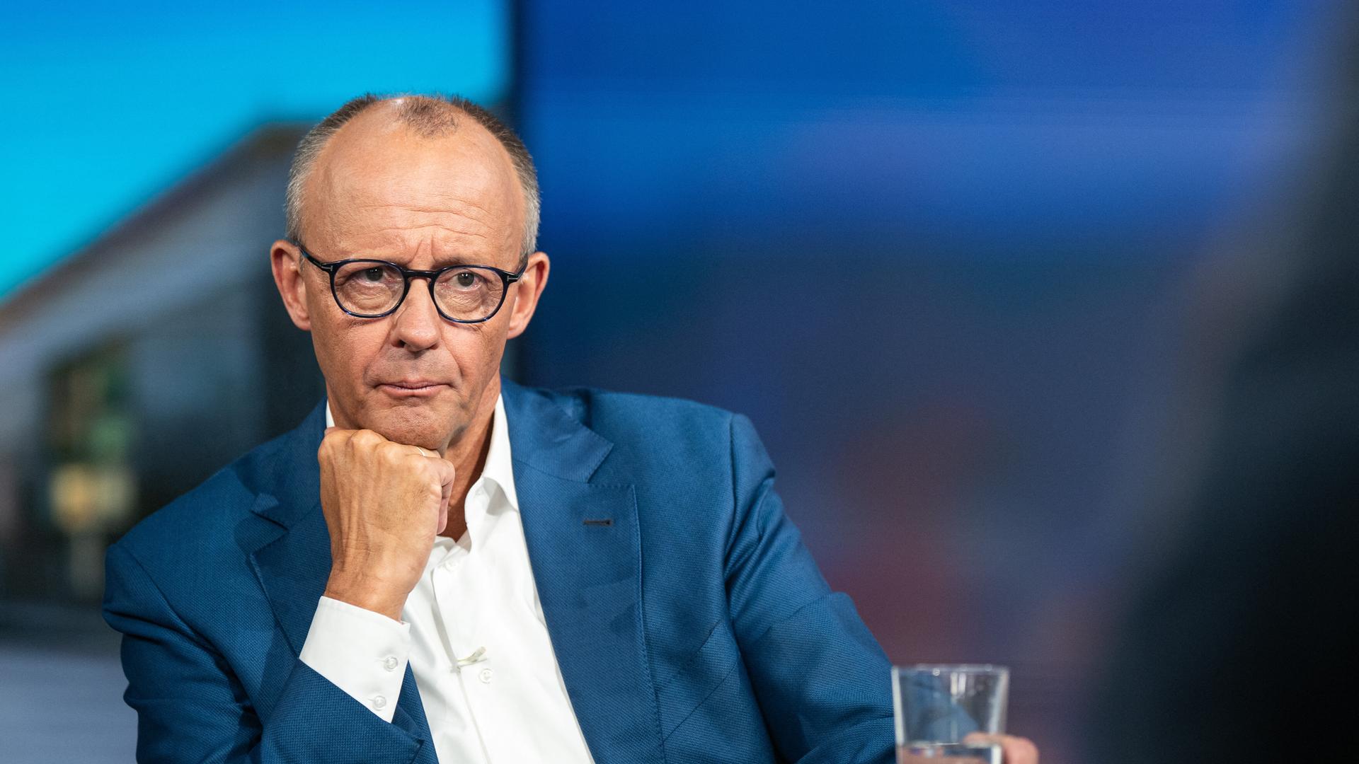 Bundeskanzler Friedrich Merz in einem TV-Studio mit Wasserglas Bundeskanzler Friedrich Merz in einem TV-Studio mit Wasserglas