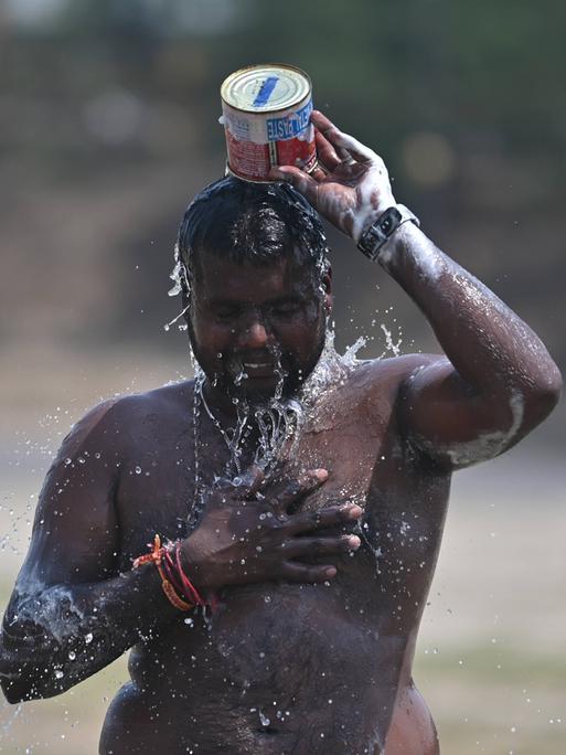 Ein Mann in Indien überschüttet sich mit Wasser Ein Mann in Indien überschüttet sich mit Wasser
