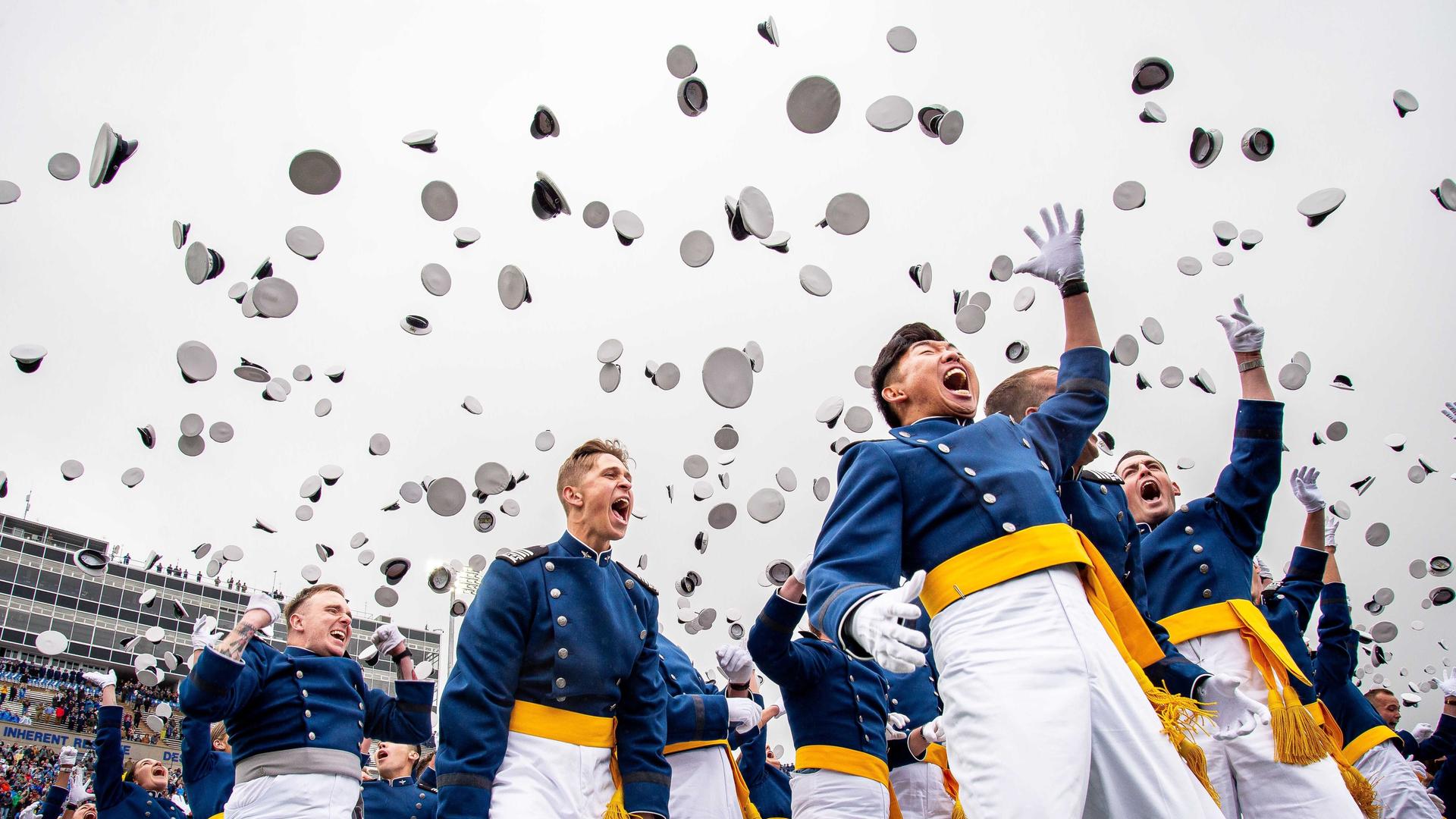 Absolventen werfen Hüte hoch Absolventen werfen Hüte hoch