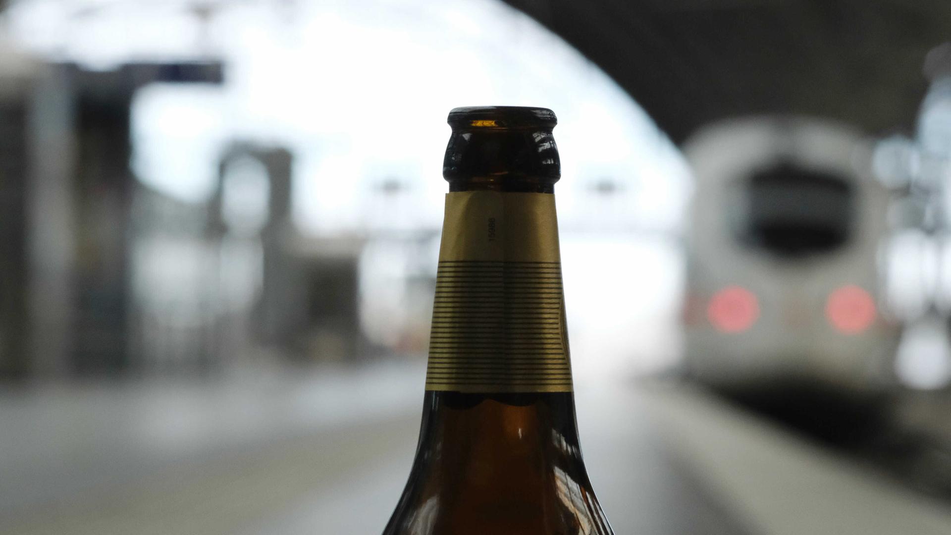 Eine leere Flasche Bier steht an einem Bahnsteig Eine leere Flasche Bier steht an einem Bahnsteig