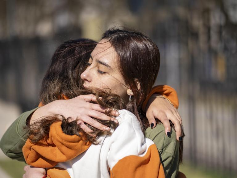 Zwei Frauen umarmen sich Zwei Frauen umarmen sich