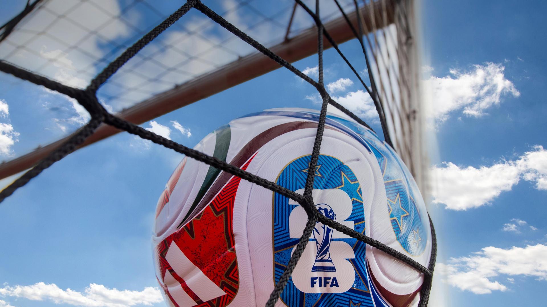 Das Bild zeigt den linken Winkel eines Tores von hinten, während im Netz ein bunter Fußball nach einem Schuss landet.