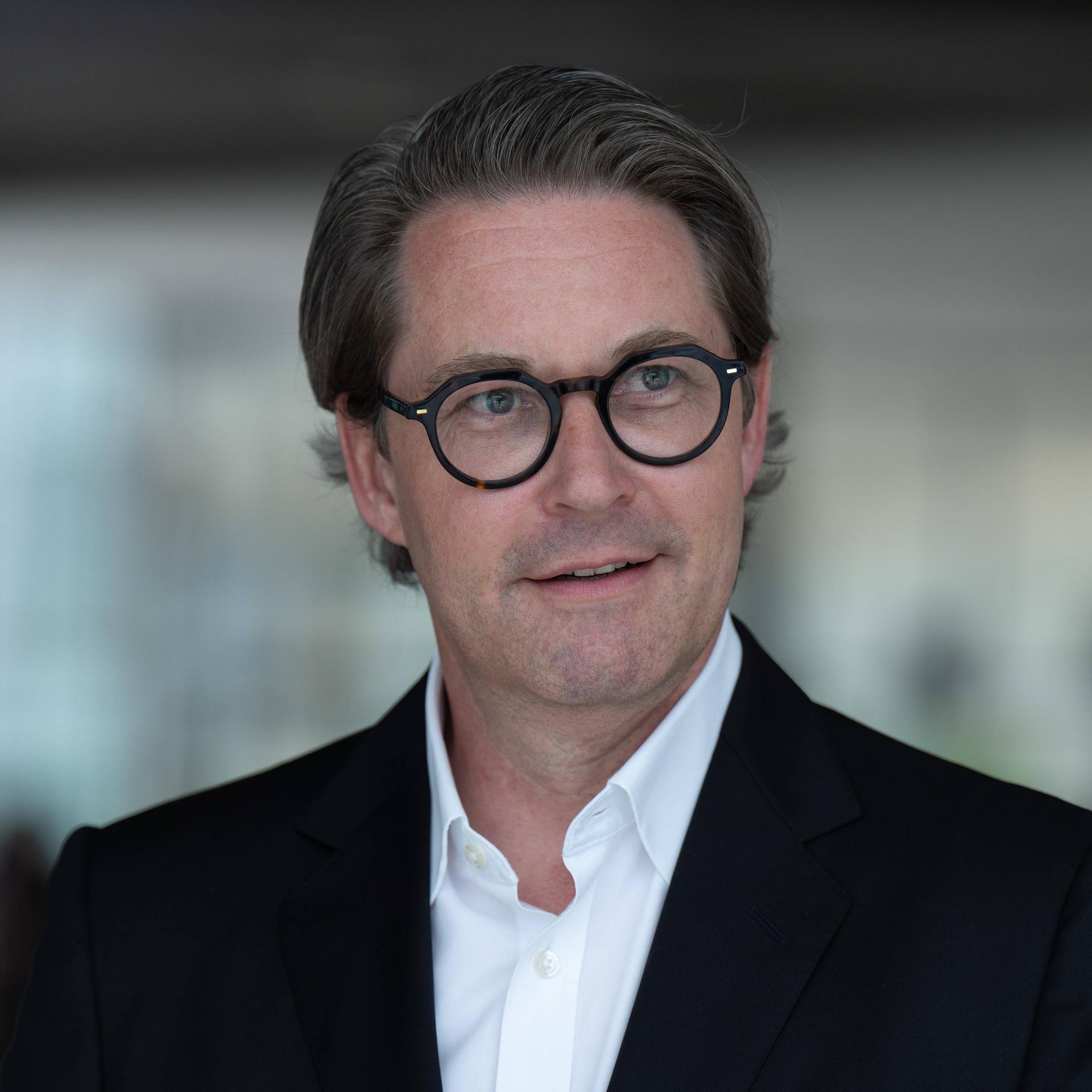 Der ehemalige Verkehrsminister Andreas Scheuer (CSU) trägt eine schwarz umrandete Brille, ein weißes Hemd, schwarzes Jacket und blickt freundlich in die Kamera.