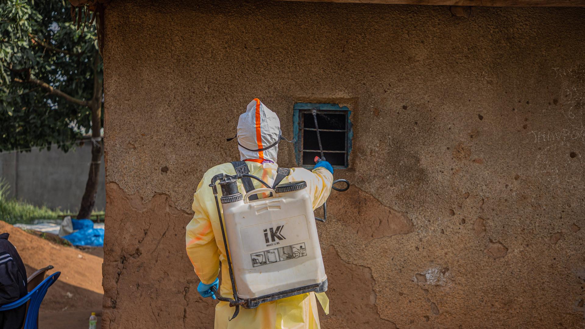 Eine medizinische Fachkraft desinfiziert das Haus einer Person, die an Ebola verstorben ist.