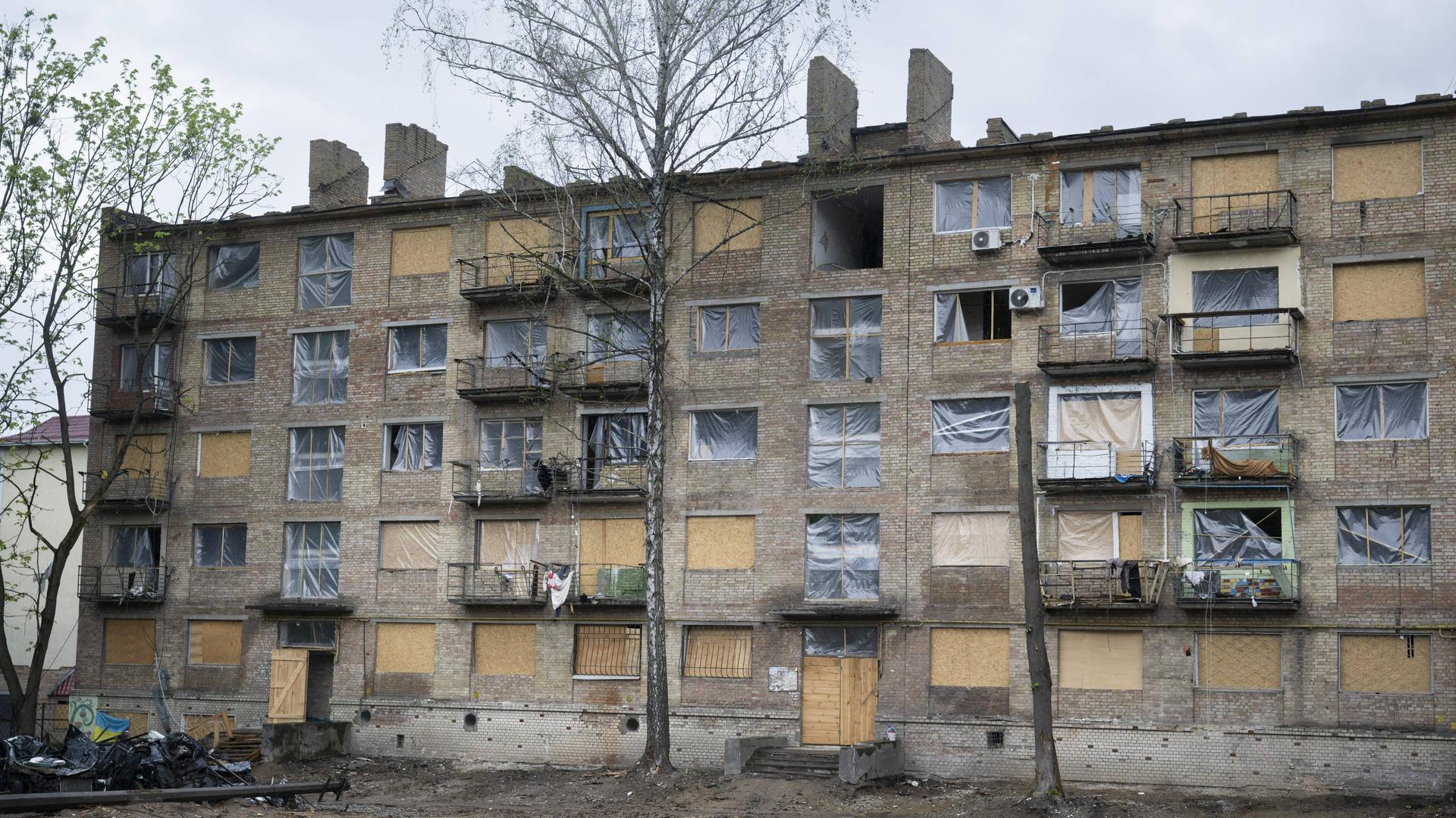 In der ukrainischen Hauptstadt Kiew steht ein Wohnhaus, bei dem die Fenster durch einen Militärangriff zerstört wurden. Anstelle der Fenster ist dort Plastikfolie angebracht.