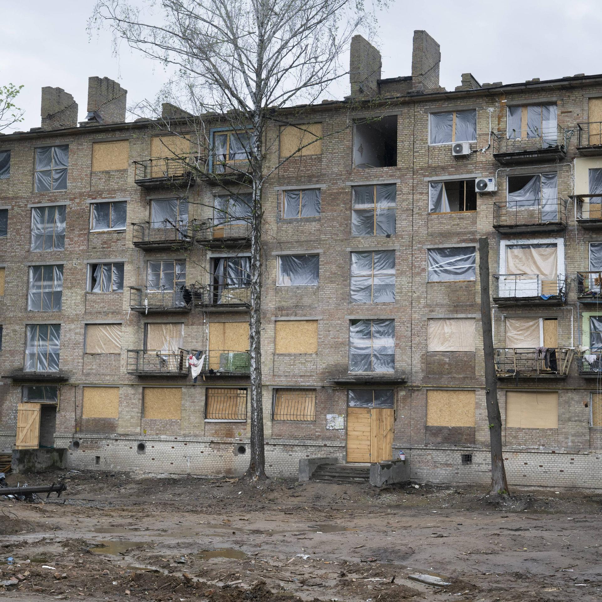 In der ukrainischen Hauptstadt Kiew steht ein Wohnhaus, bei dem die Fenster durch einen Militärangriff zerstört wurden. Anstelle der Fenster ist dort Plastikfolie angebracht.
