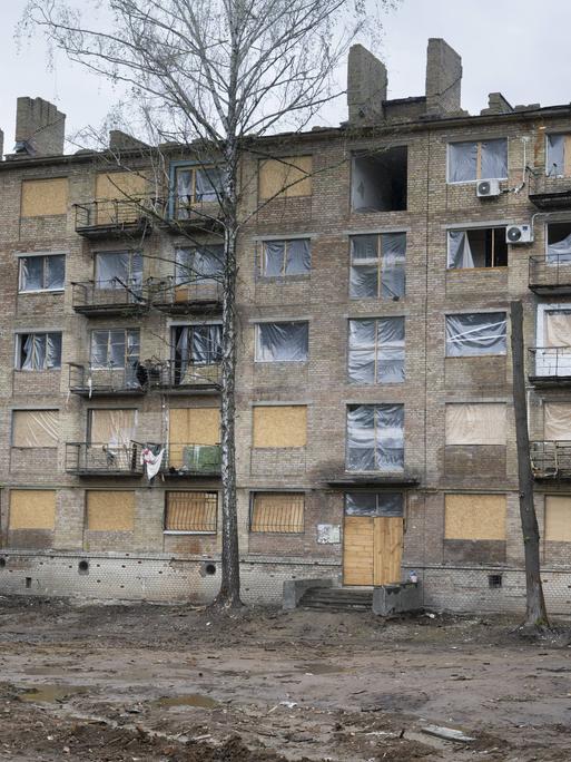 In der ukrainischen Hauptstadt Kiew steht ein Wohnhaus, bei dem die Fenster durch einen Militärangriff zerstört wurden. Anstelle der Fenster ist dort Plastikfolie angebracht.