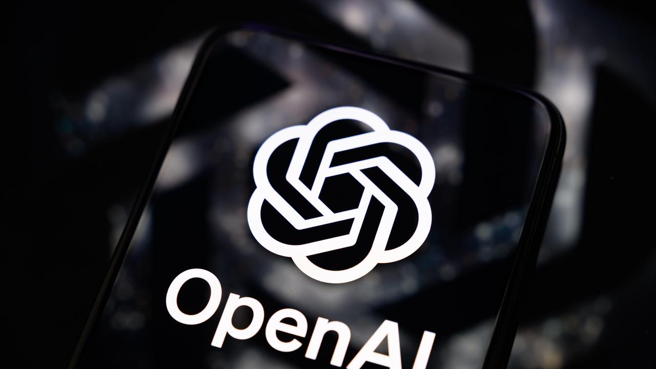 Das Logo - eine Art Kranz aus zwei Strängen - und der Schriftzug von OpenAI in weiß auf einem Smartphone-Bildschirm.