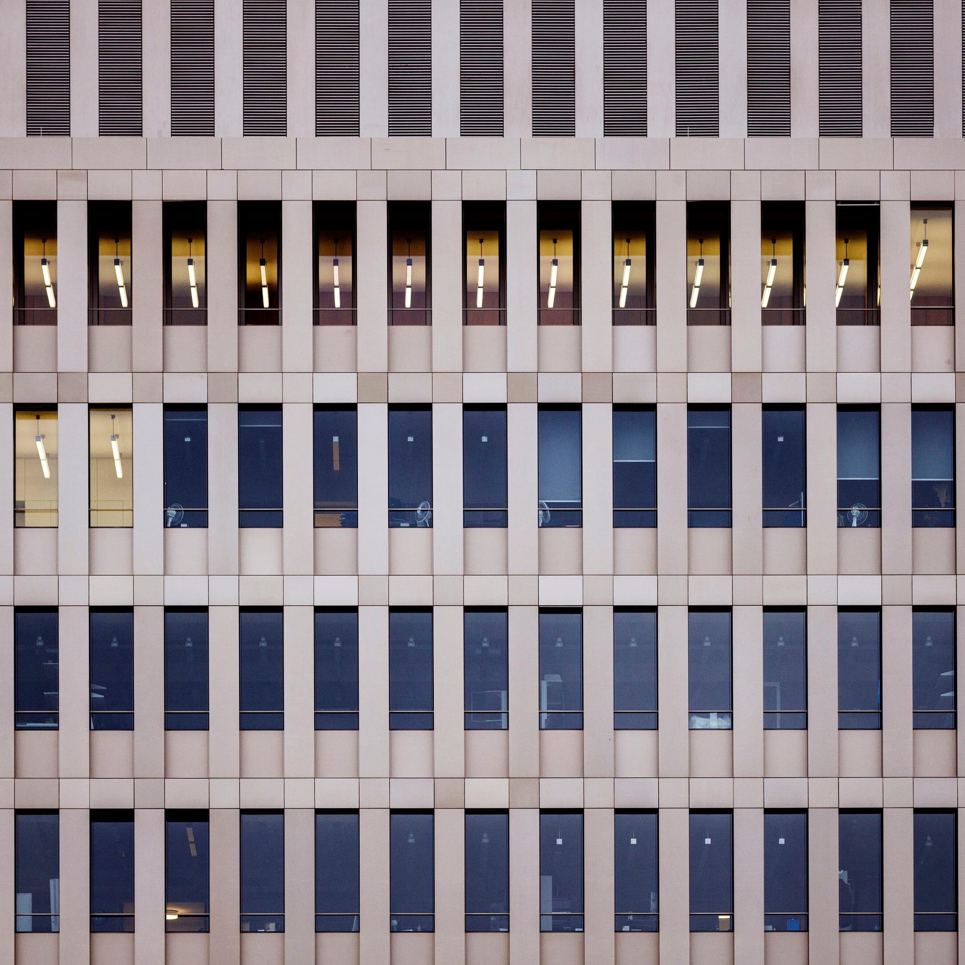 Blick von außen auf das Gebäude des Bundesnachrichtendienstes in Berlin. Mehrere Fensterreihen, in wenigen Fenstern brennt Licht. Es ist tags.