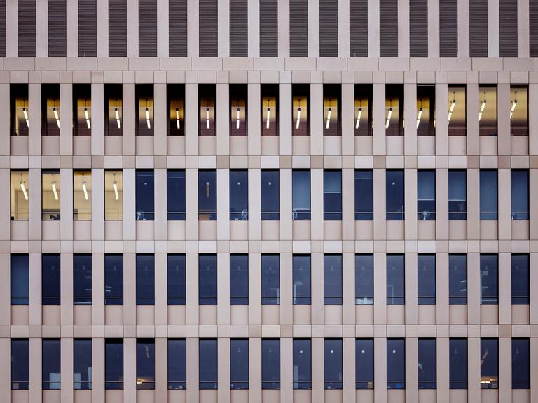 Blick von außen auf das Gebäude des Bundesnachrichtendienstes in Berlin. Mehrere Fensterreihen, in wenigen Fenstern brennt Licht. Es ist tags.