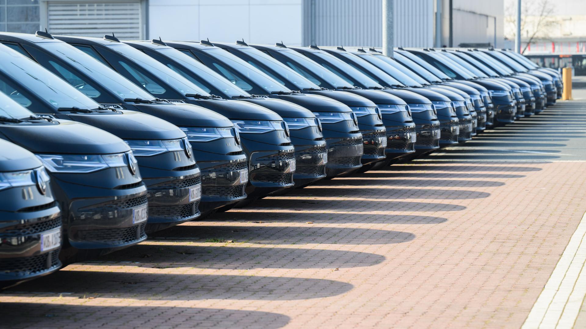 Viele schwarze Autos des gleichen VW-Modells stehen in einer Reihe