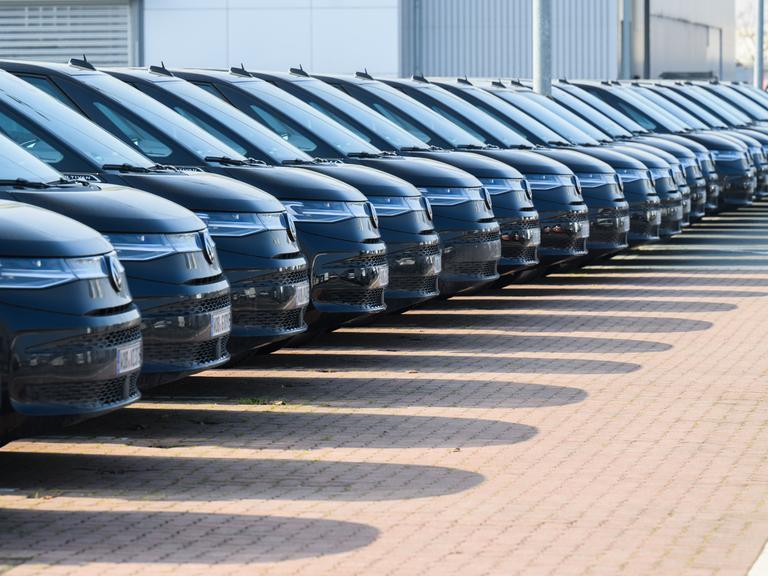 Viele schwarze Autos des gleichen VW-Modells stehen in einer Reihe