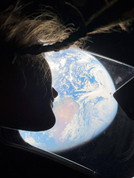 Orion-Kapsel, Weltraum: NASA-Astronautin Christina Koch blickt aus einem der Hauptkabinenfenster der Orion-Kapsel zurück zur Erde, während die Besatzung auf dem Weg zum Mond ist.