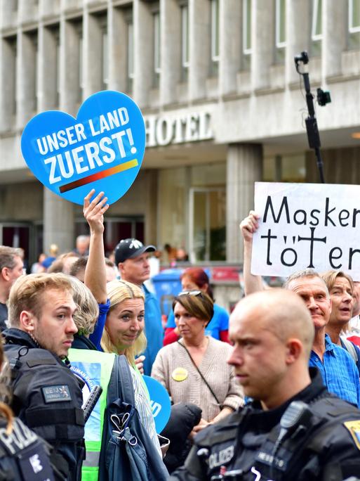 Foto einer Querdenker-Demo in Frankfurt am Main am 22.10.2022, bei der Schilder mit der Aufschrift "Deutschland zuerst!" und "Masken töten" hochgehalten werden.
