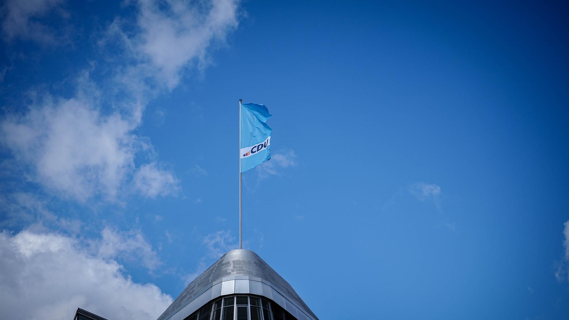 Eine Fahne mit dem neuen CDU-Logo weht auf dem Konrad-Adenauer-Haus, der CDU-Parteizentrale, im Wind.