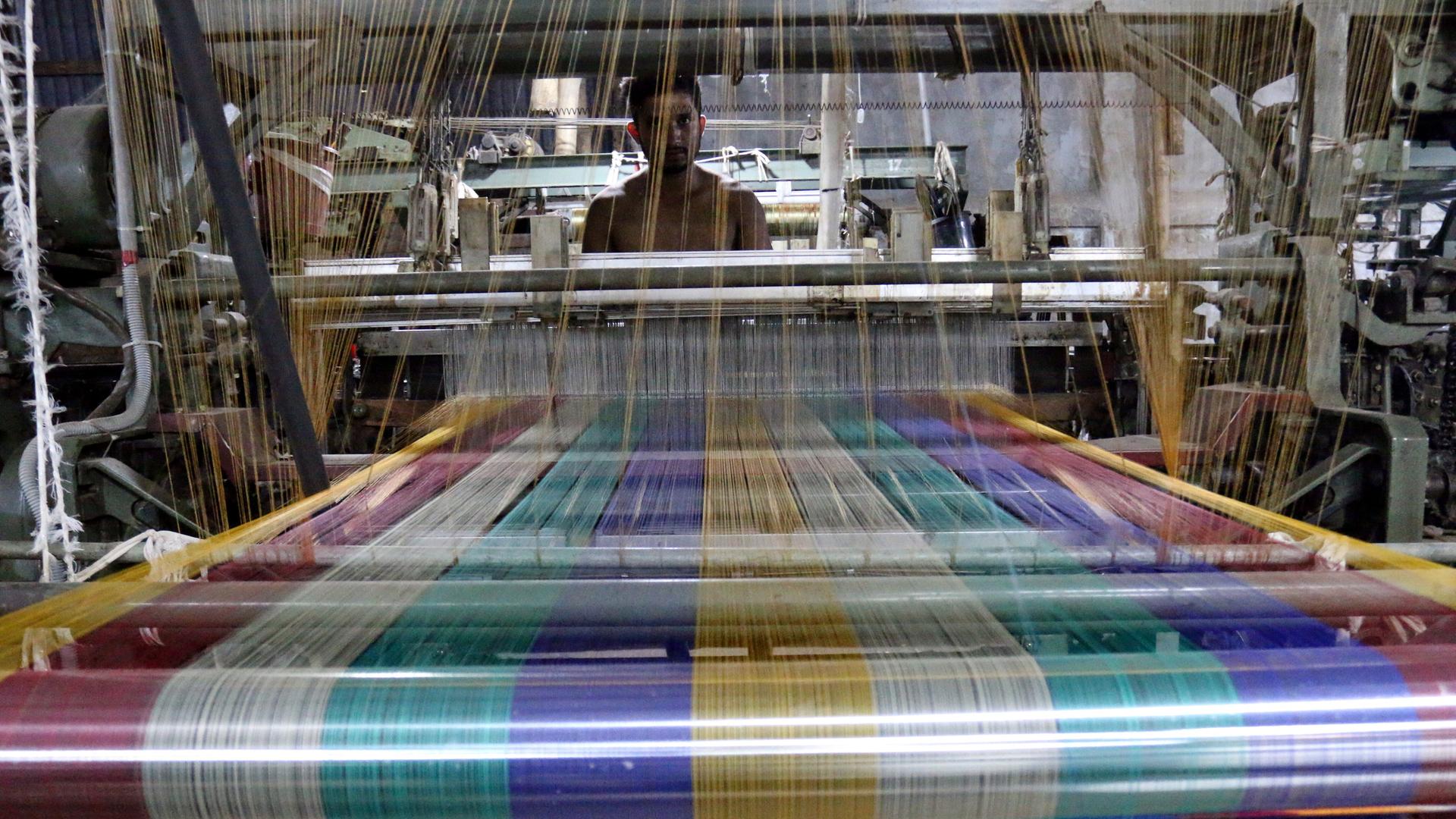 Ein Arbeiter an einem Webstuhl in einer Textilfabrik in Bangladesch