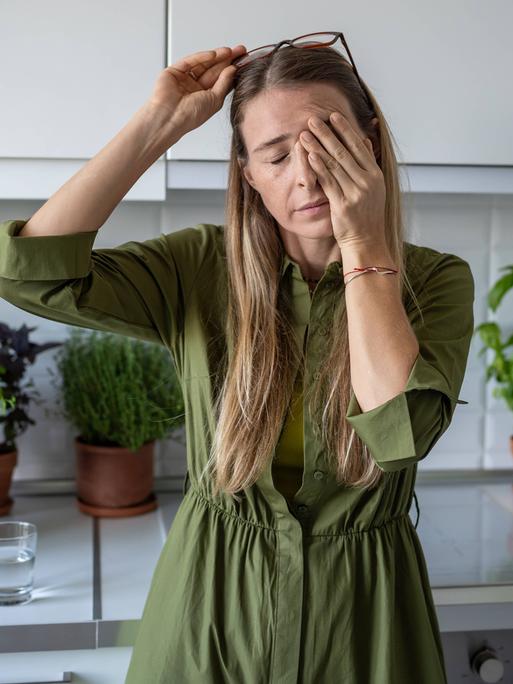 Eine verschlafene Frau reibt sich die Augen Eine verschlafene Frau reibt sich die Augen