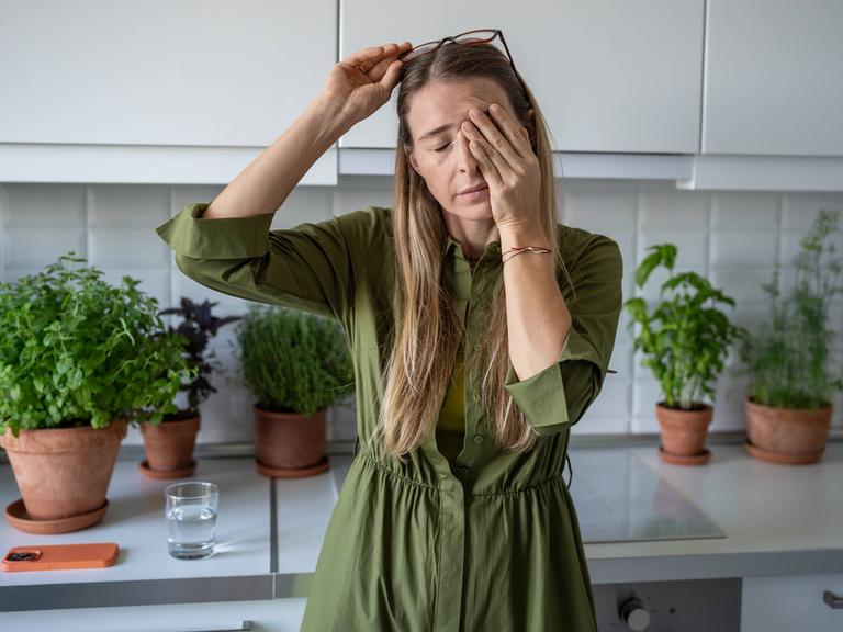 Eine verschlafene Frau reibt sich die Augen Eine verschlafene Frau reibt sich die Augen