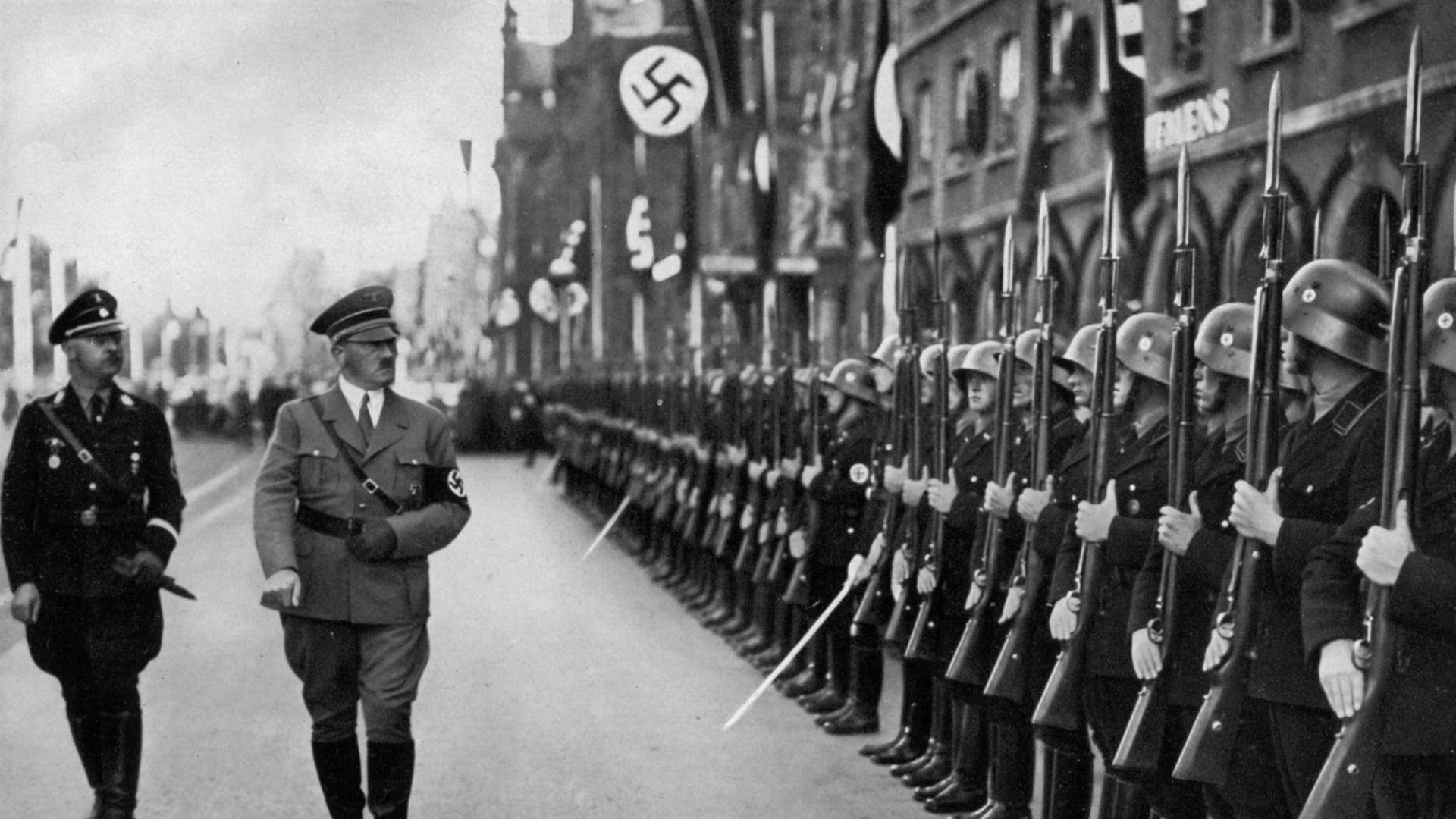 Adolf Hitler inspiziert die Leibstandarte-Truppen auf dem Reichsparteitag in Nürnberg, Deutschland, 1935. Hitler (1889–1945) inspiziert Soldaten der Leibstandarte SS Adolf Hitler, seines persönlichen Leibgarderegiments. Er wird von Reichsführer Heinrich…