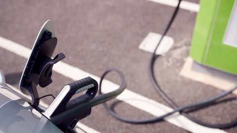 Ein E-Auto ist an einer Ladestation angeschlossen. 