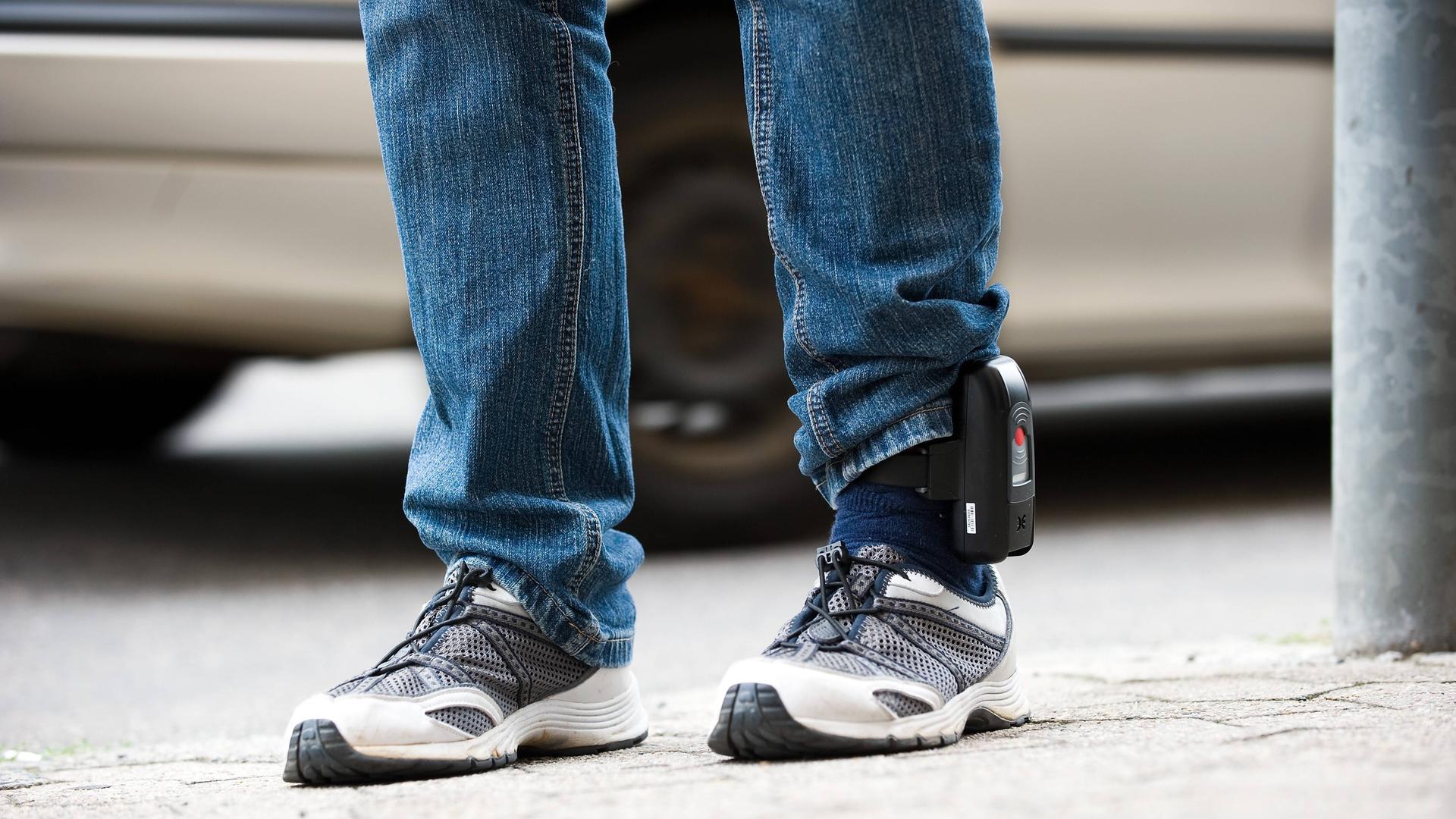 Elektronische Fußfessel am linken Knöchel eines Beins