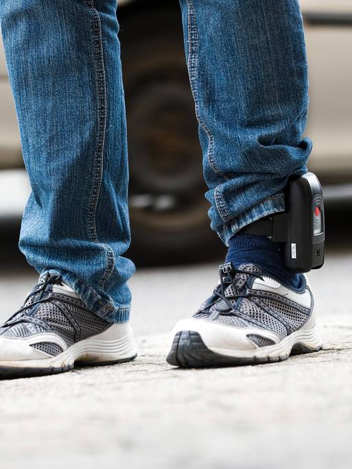 Elektronische Fußfessel am linken Knöchel eines Beins