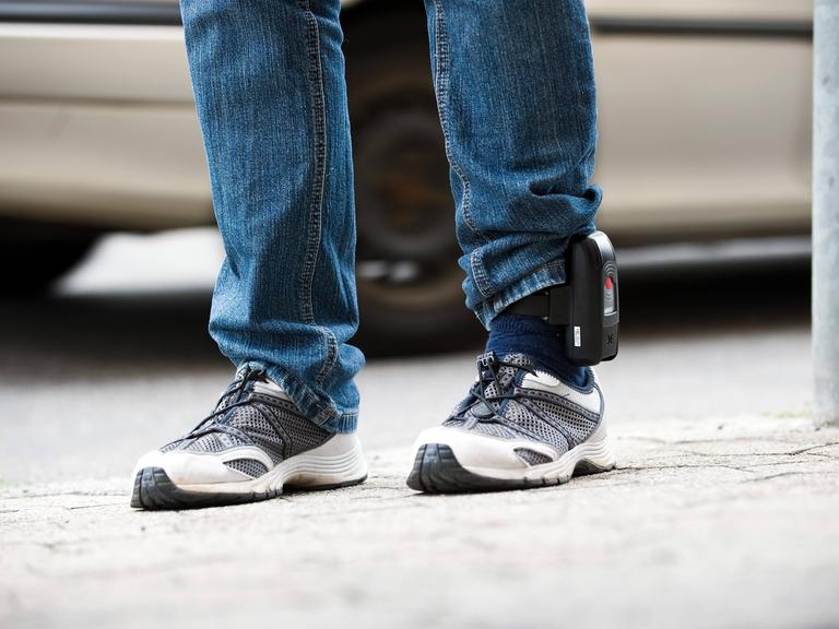 Elektronische Fußfessel am linken Knöchel eines Beins