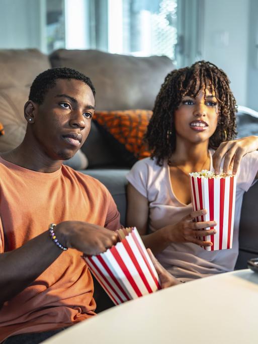 Eine Frau und ein Mann essen Popcorn