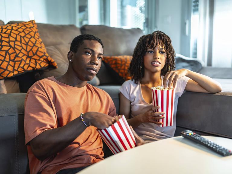 Eine Frau und ein Mann essen Popcorn