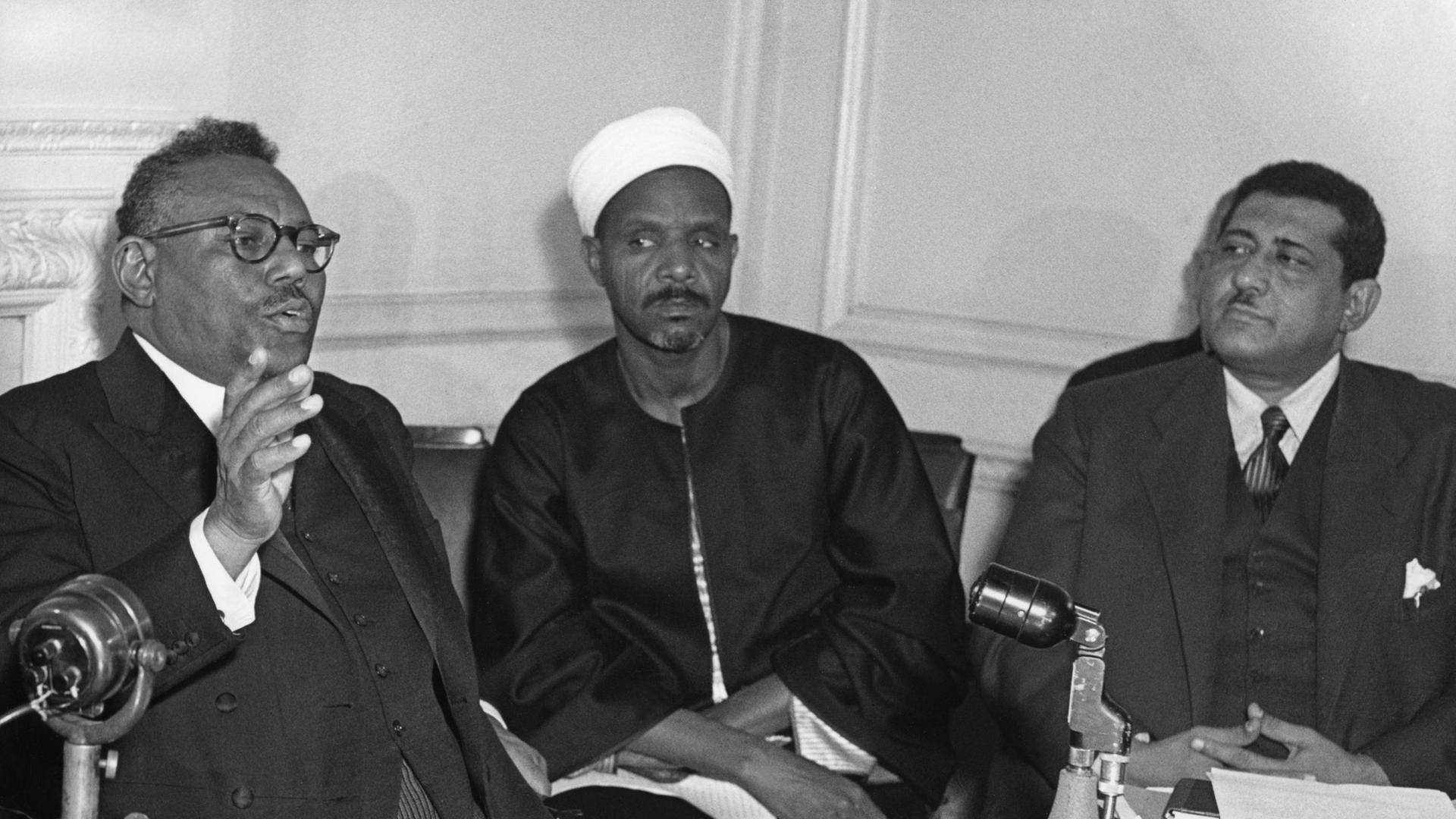 15.11.1954: Sudans erster Premierminister Sayed Ismail El Azhari (links) bei einer Pressekonferenz in London. Neben ihm der sudanesische Justizminister Ali Abd El Rahman und Sozialminister Sayed Yahia Fadly. Bei den Parlamentswahlen 1954 gewannen El…